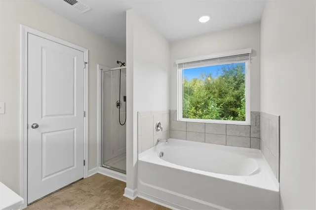 a white bath tub sitting next to a shower