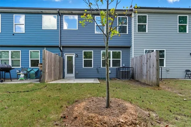 a backyard of a house with sofas table and chairs