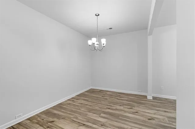a view of a room with wooden floor and chandelier