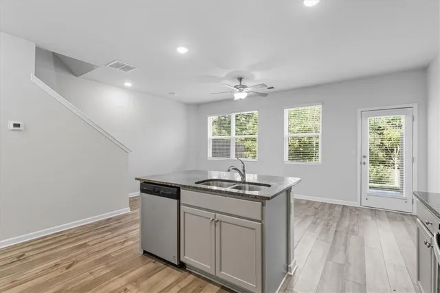 a kitchen with a sink and wooden floor