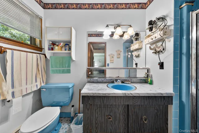 a bathroom with a sink vanity mirror and toilet