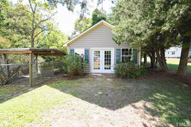 a view of backyard with potted plants and large tree