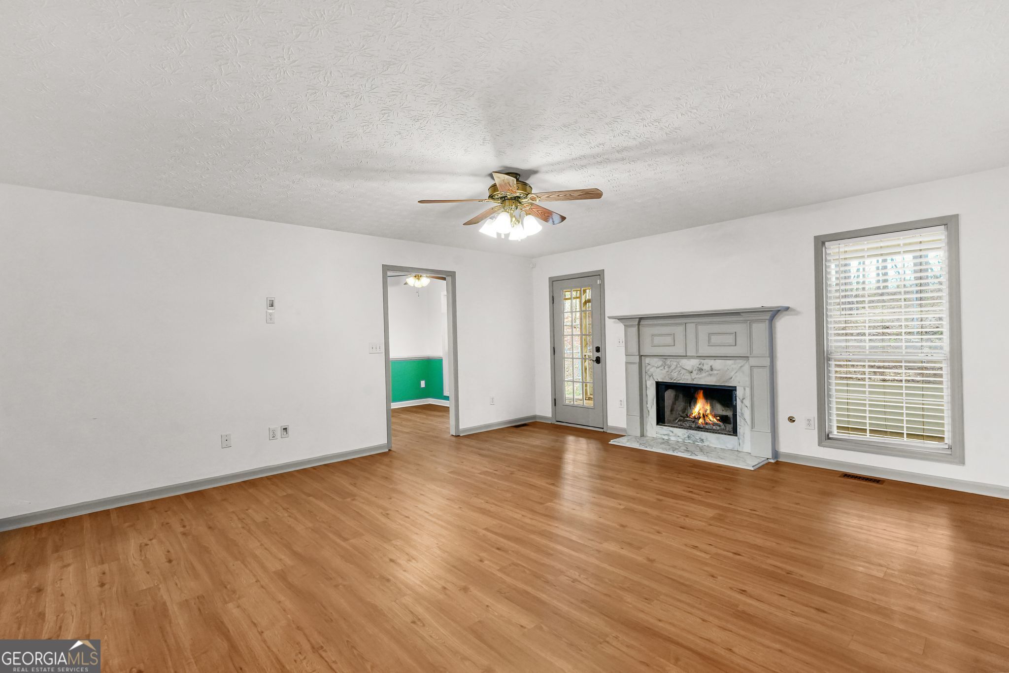 156 Pine Street Covington, GA 30014 - Photo 14 of 37 a view of empty room with wooden floor and fireplace