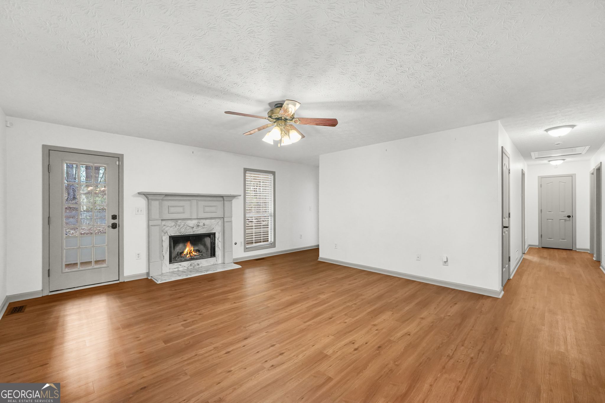 156 Pine Street Covington, GA 30014 - Photo 15 of 37 a view of empty room with wooden floor and fireplace