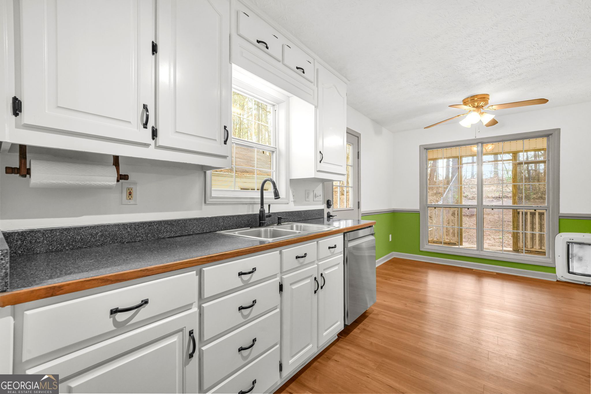 156 Pine Street Covington, GA 30014 - Photo 17 of 37 a large kitchen with granite countertop a large window and white cabinets