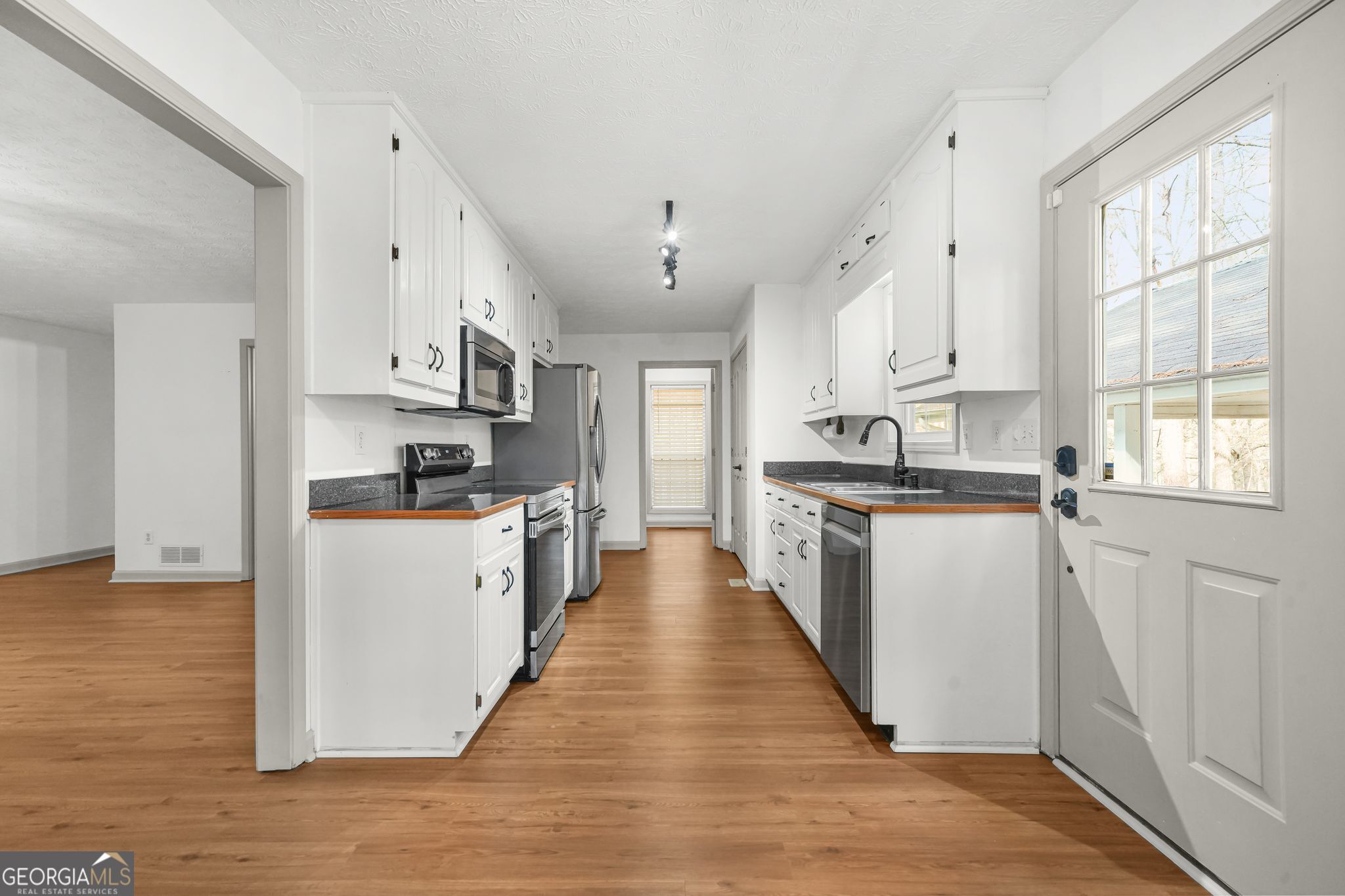 156 Pine Street Covington, GA 30014 - Photo 20 of 37 a kitchen with kitchen island granite countertop a large counter top space a sink stainless steel appliances and cabinets