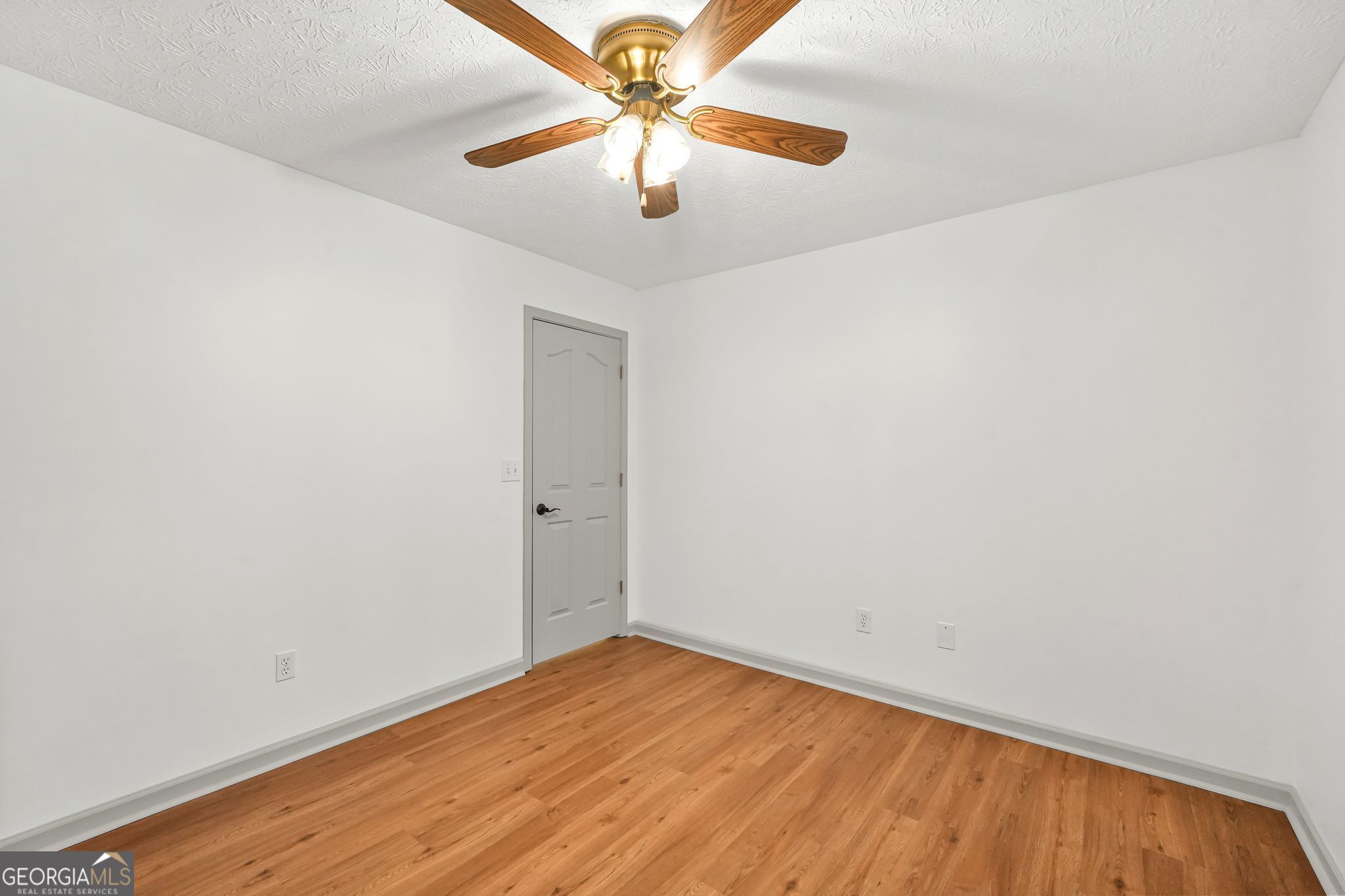 156 Pine Street Covington, GA 30014 - Photo 28 of 37 a view of a room with wooden floor and a ceiling fan