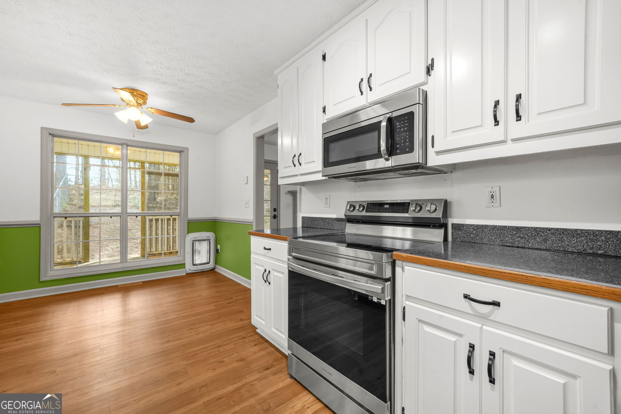 156 Pine Street Covington, GA 30014 - Photo 3 of 37 a kitchen with stainless steel appliances granite countertop a stove a sink and a microwave