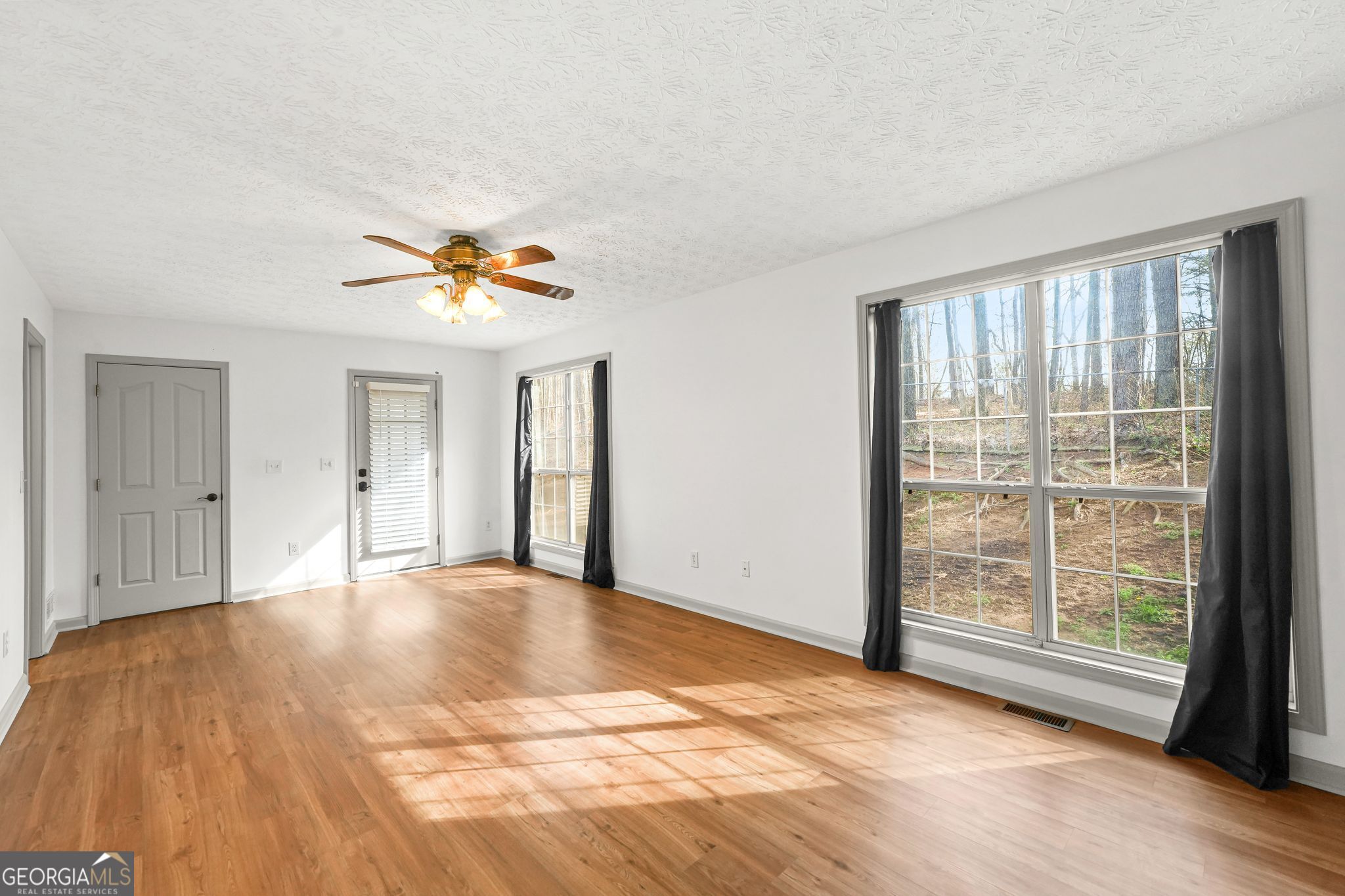 156 Pine Street Covington, GA 30014 - Photo 5 of 37 a view of empty room with wooden floor and fan