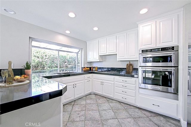 a kitchen with a sink window and cabinets
