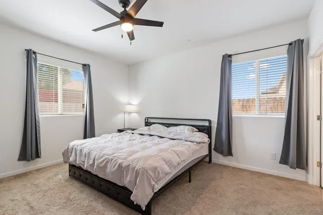 a bedroom with a bed lamp and a window