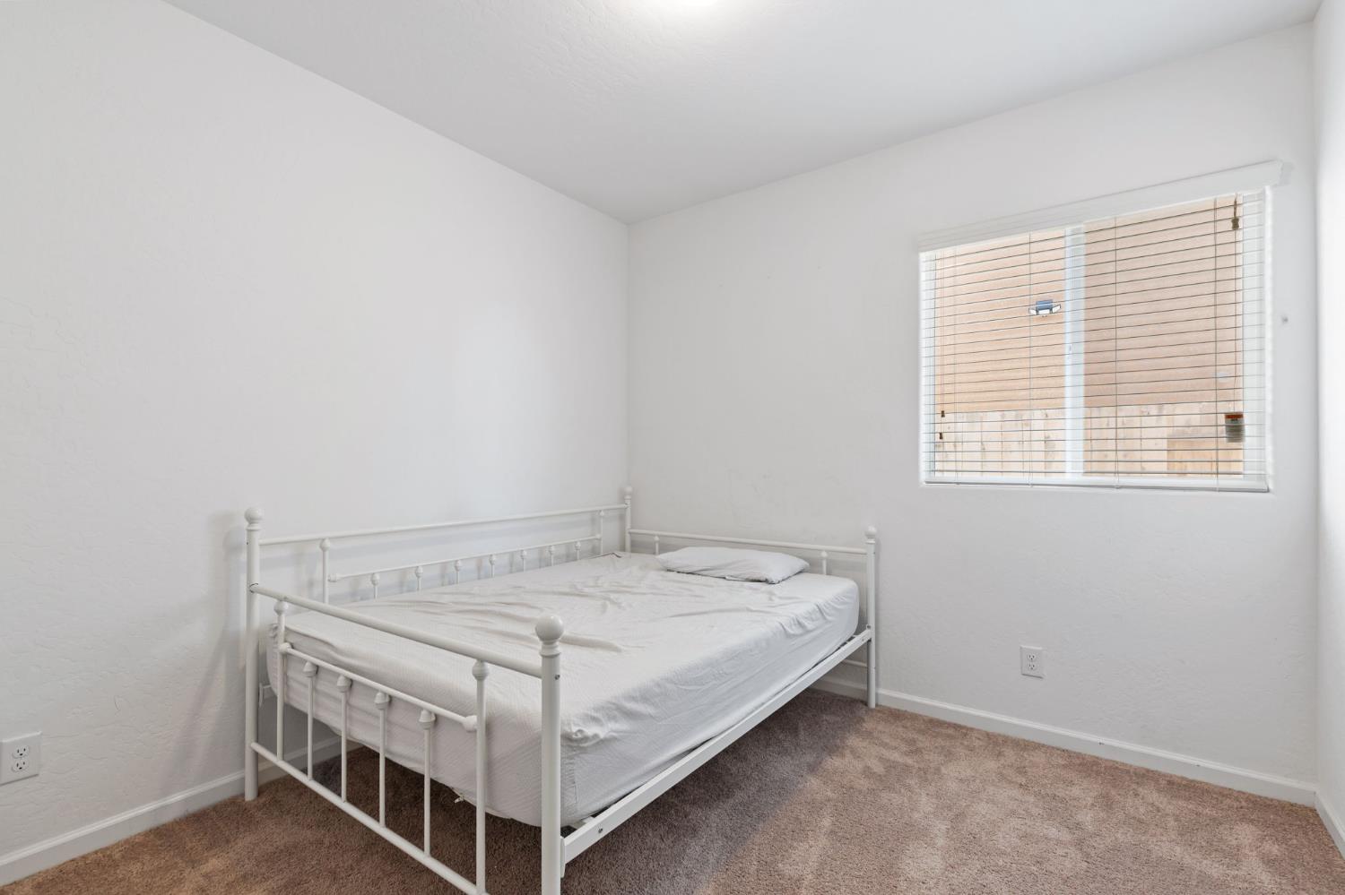 282 Rosebriar Street Madera, CA 93638 - Photo 18 of 28 a bed sitting in a bedroom next to a window