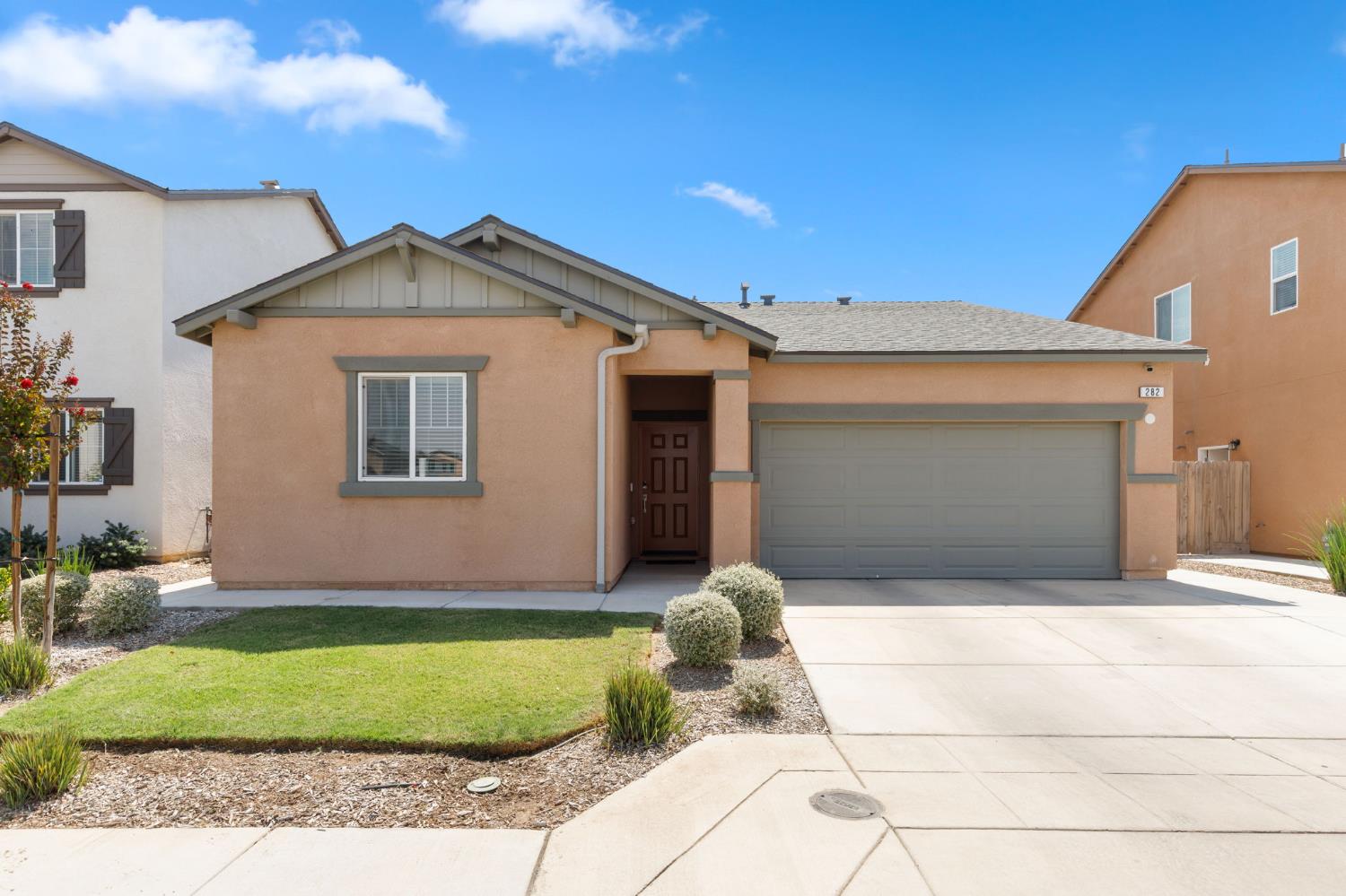 282 Rosebriar Street Madera, CA 93638 - Photo 23 of 28 a front view of a house with a yard and garage