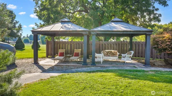 a patio with a table and chairs under an umbrella