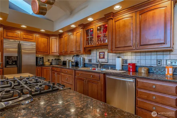a kitchen with stainless steel appliances granite countertop a stove sink and cabinets