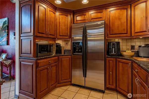 a kitchen with stainless steel appliances granite countertop a refrigerator and cabinets