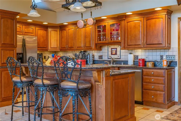 a kitchen with stainless steel appliances granite countertop a refrigerator and a stove top oven