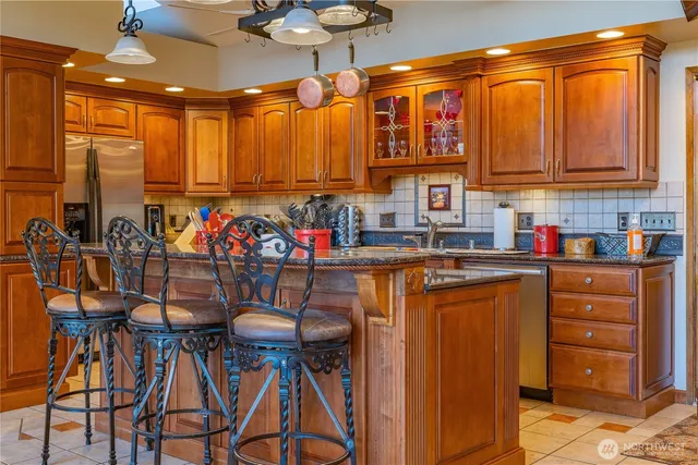 a kitchen with stainless steel appliances granite countertop a refrigerator and a stove top oven