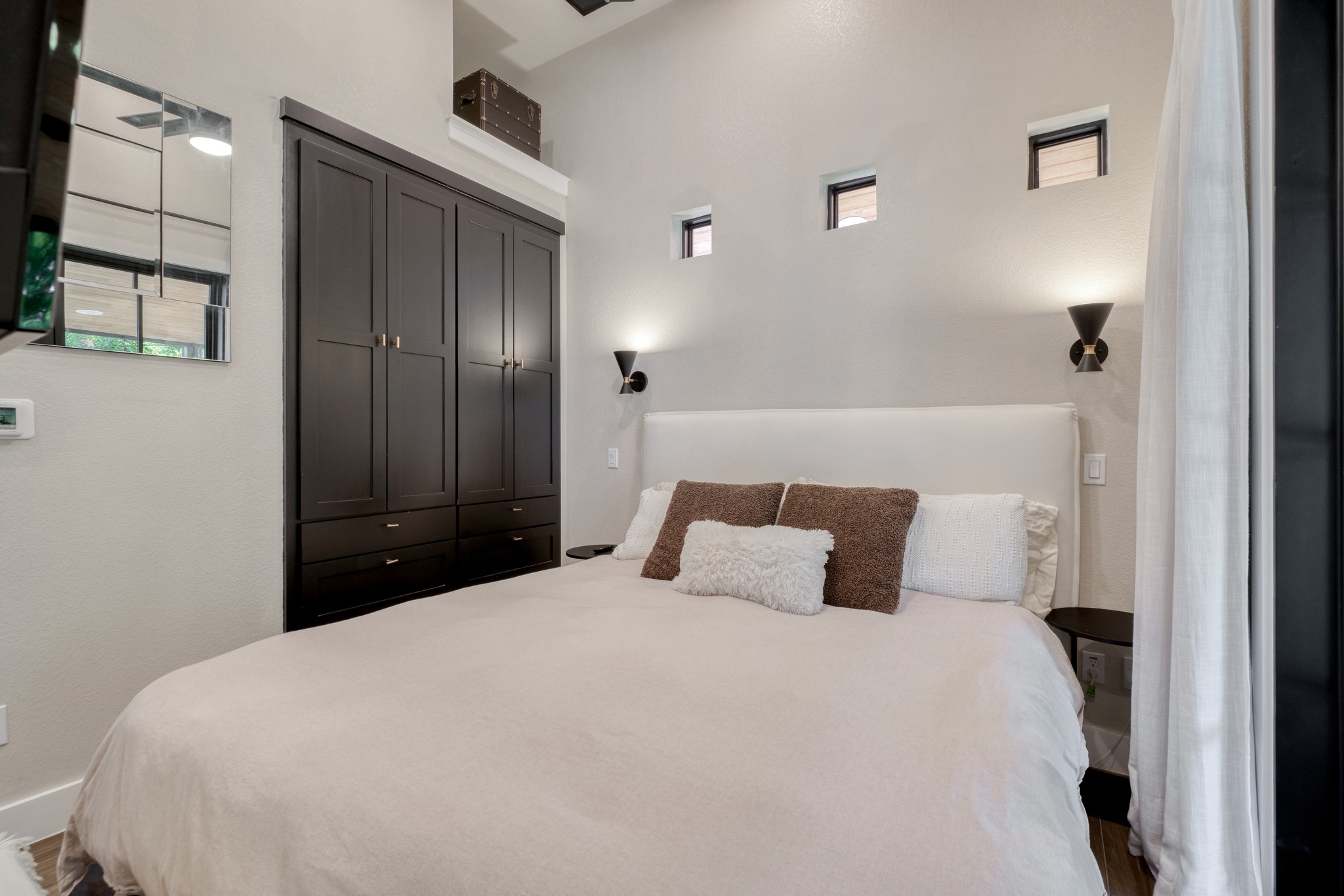 1904 East 16th Street, Unit 2 Austin, TX 78702 - Photo 14 of 20 Integrated dark wood-finish cabinetry with drawers, complemented by an upholstered headboard