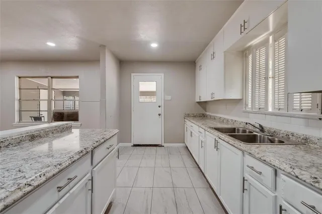 a large kitchen with granite countertop a sink and dishwasher stove top oven