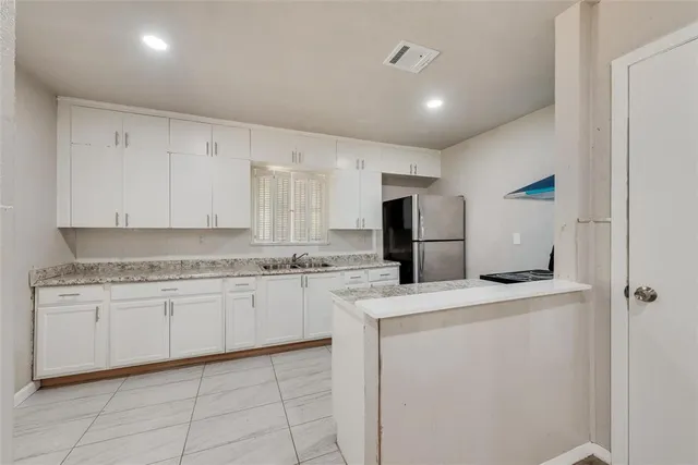 a kitchen with white cabinets and appliances