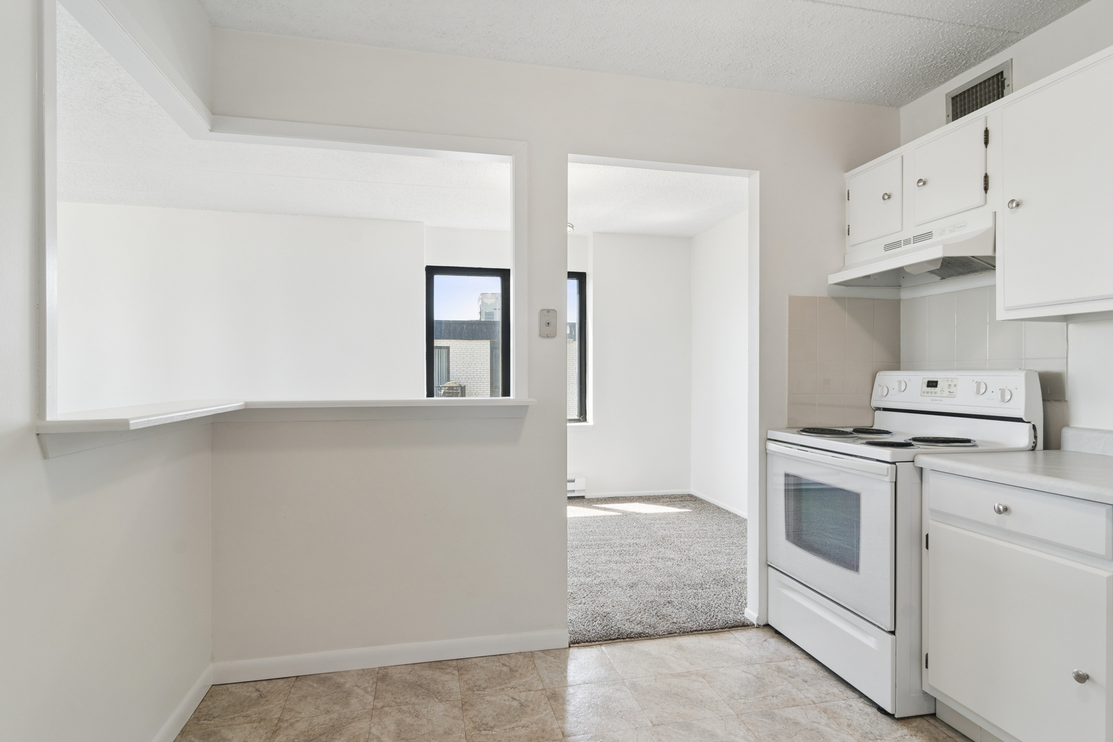 9701 North Dee Road, Unit 6N Niles, IL 60714 - Photo 4 of 13 a kitchen with white cabinets and white appliances