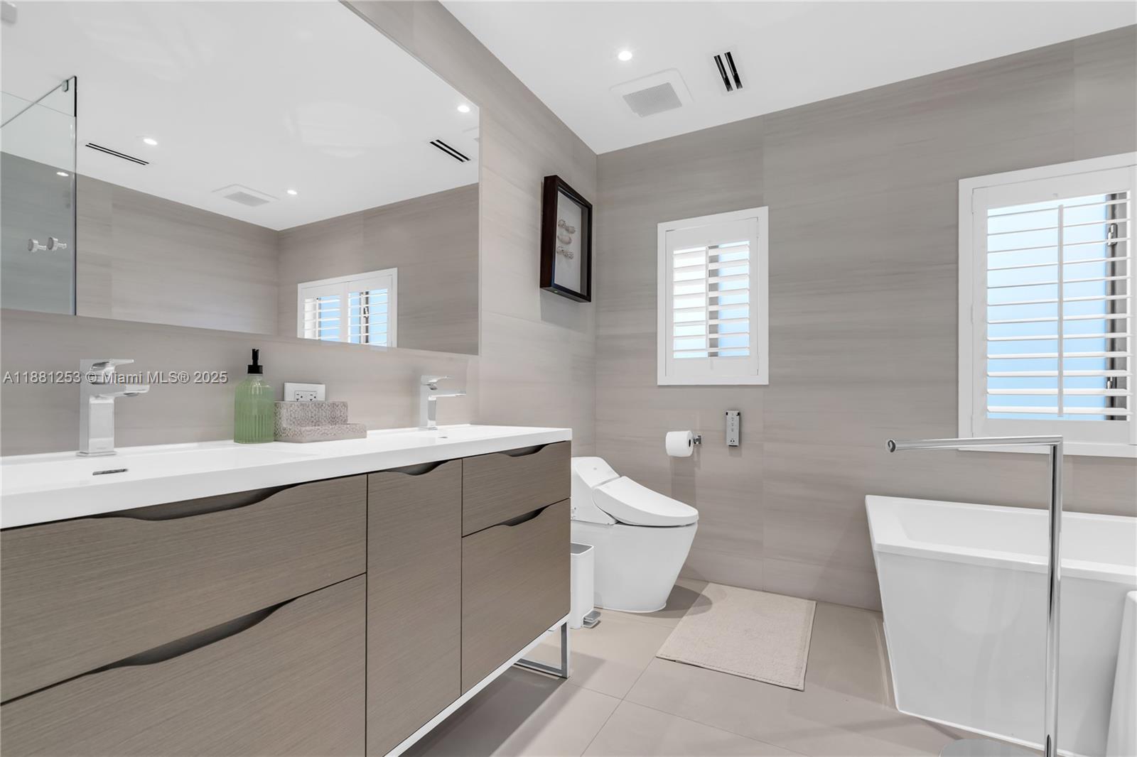 340 Woodcrest Road Key Biscayne, FL 33149 - Photo 22 of 51 a bathroom with a double vanity sink mirror bathtub and toilet