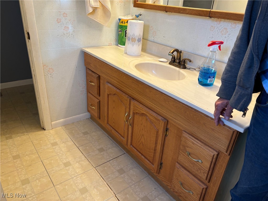 9517 Brick Church Road Cambridge, OH 43725 - Photo 9 of 26 Bathroom with tile patterned floors, vanity, and backsplash