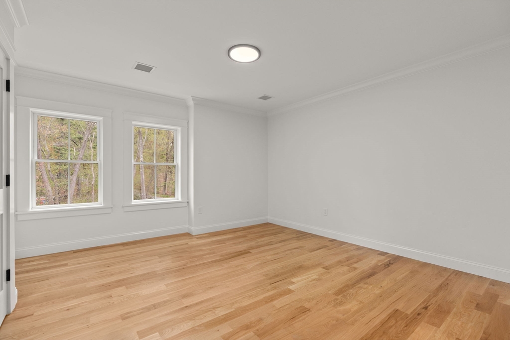 82 Deer Path Lane Weston, MA 02493 - Photo 36 of 42 an empty room with wooden floor and windows
