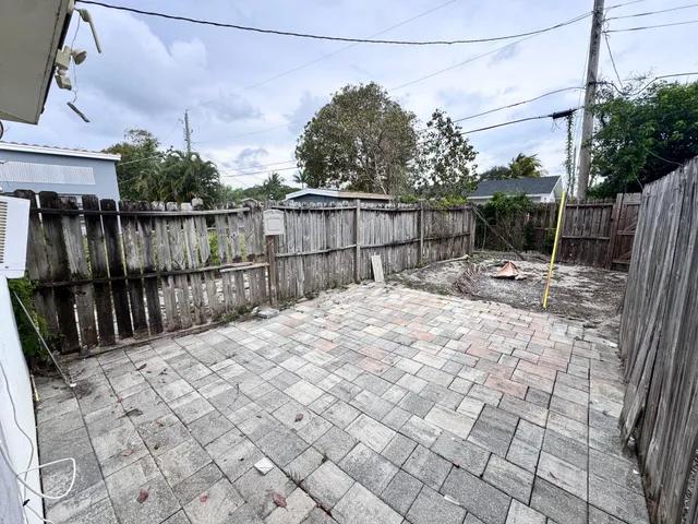a view of backyard with wooden fence and trees