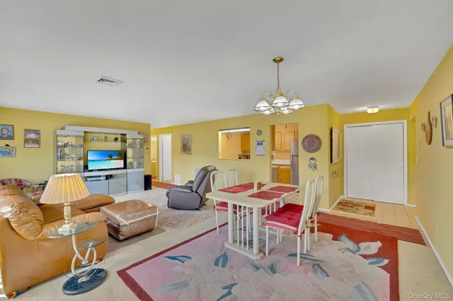 a living room with furniture a fireplace and a chandelier