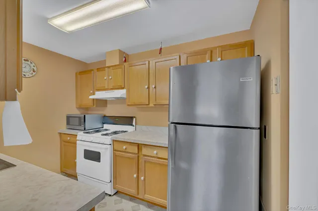 a white refrigerator freezer and a stove sitting inside of a kitchen