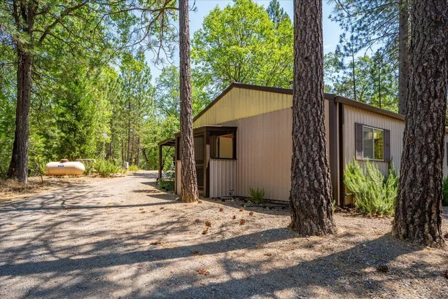 a view of a house with backyard and trees
