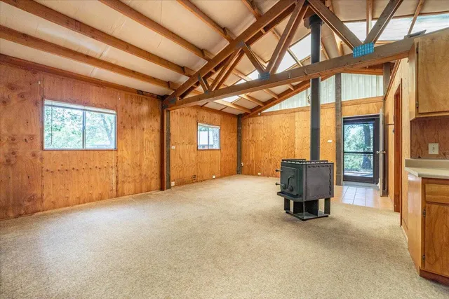a view of a two room with wooden floor and iron stairs