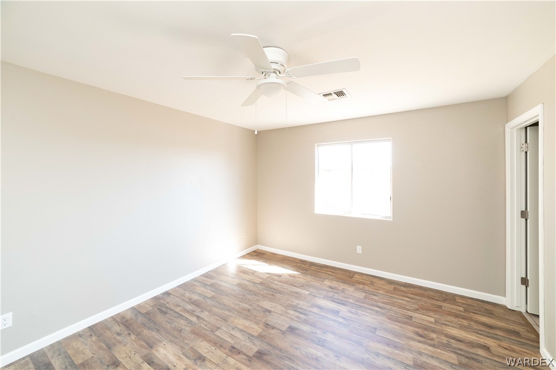 3556 North Willow Road Kingman, AZ 86409 - Photo 19 of 48 an empty room with wooden floor fan and windows