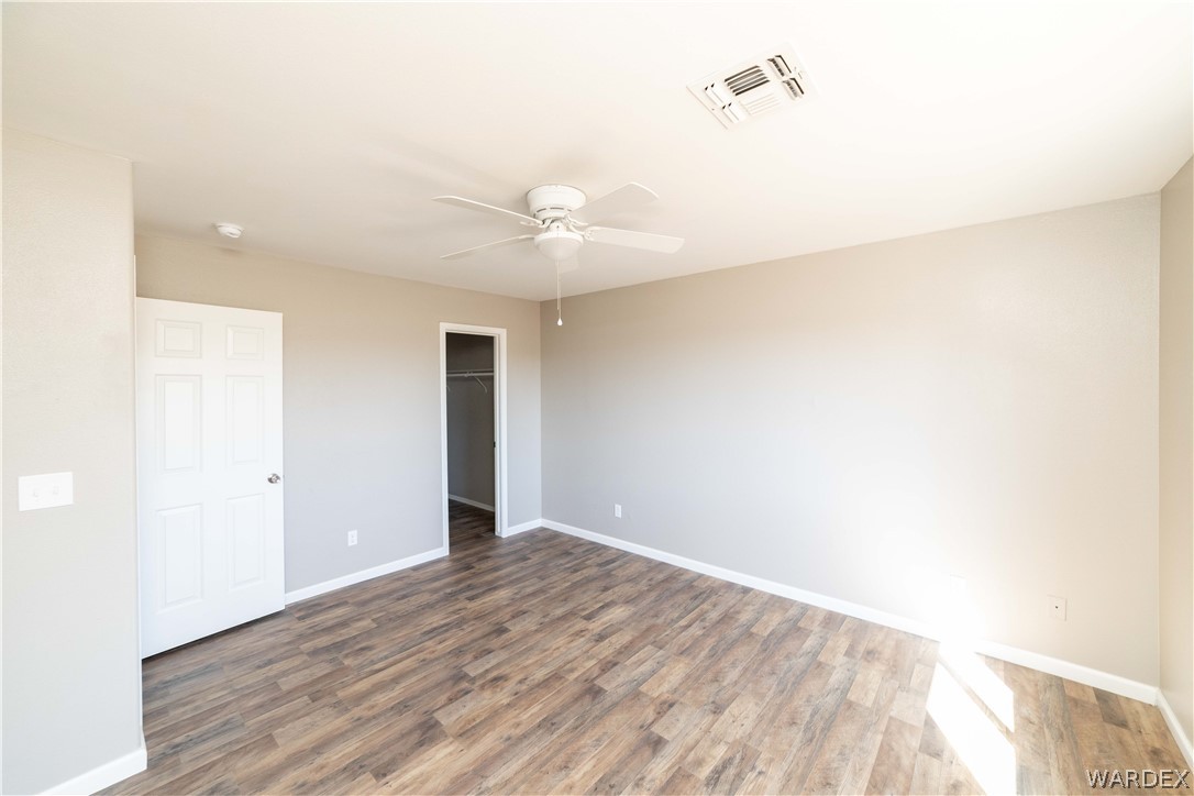 3556 North Willow Road Kingman, AZ 86409 - Photo 21 of 48 a view of an empty room with wooden floor and a ceiling fan