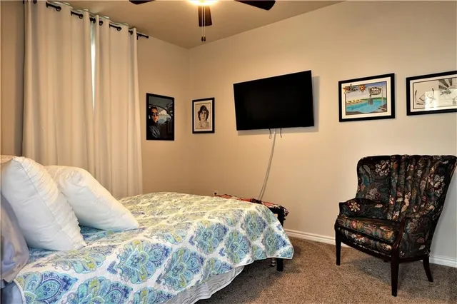 a bedroom with a bed a couch and a flat screen tv
