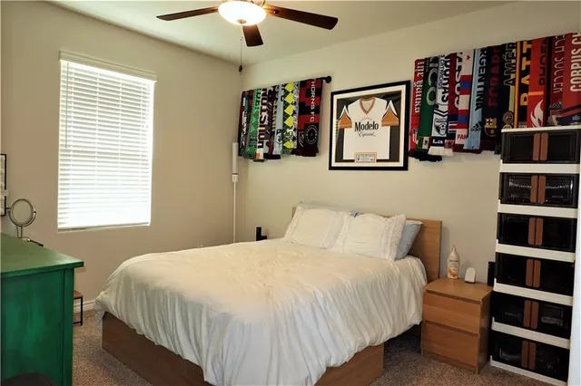 a bedroom with a bed a wall painting and a large window