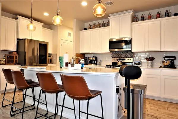 a kitchen with a sink a stove and chairs