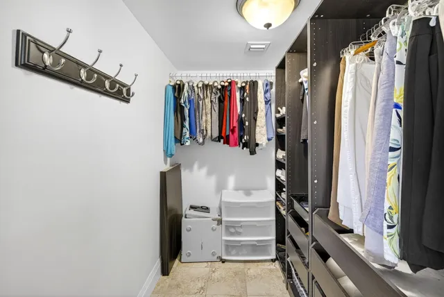 a view of walk in closet with clothes and shoes