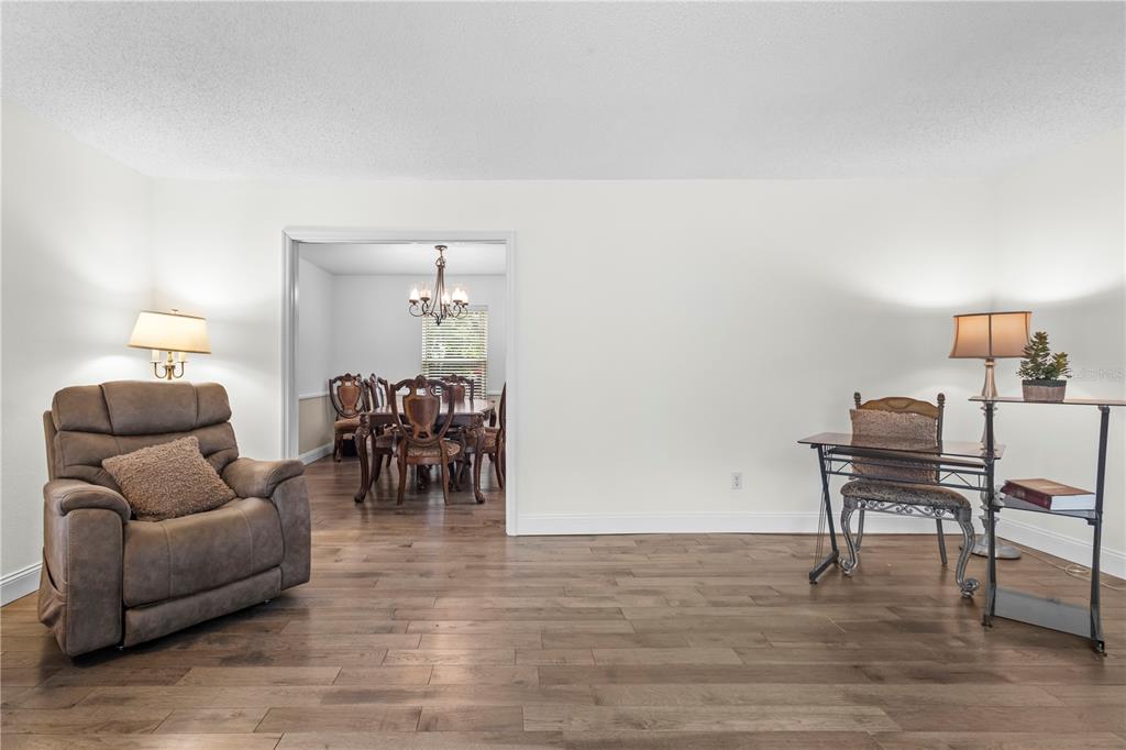 1437 Glenview Road Palm Harbor, FL 34683 - Photo 29 of 69 a living room with furniture and a dining table with a potted plant