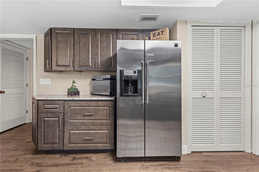 1437 Glenview Road Palm Harbor, FL 34683 - Photo 34 of 69 a kitchen with granite countertop a refrigerator and cabinets