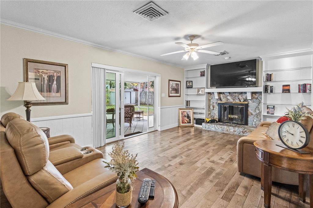1437 Glenview Road Palm Harbor, FL 34683 - Photo 40 of 69 a living room with furniture a flat screen tv and a fireplace