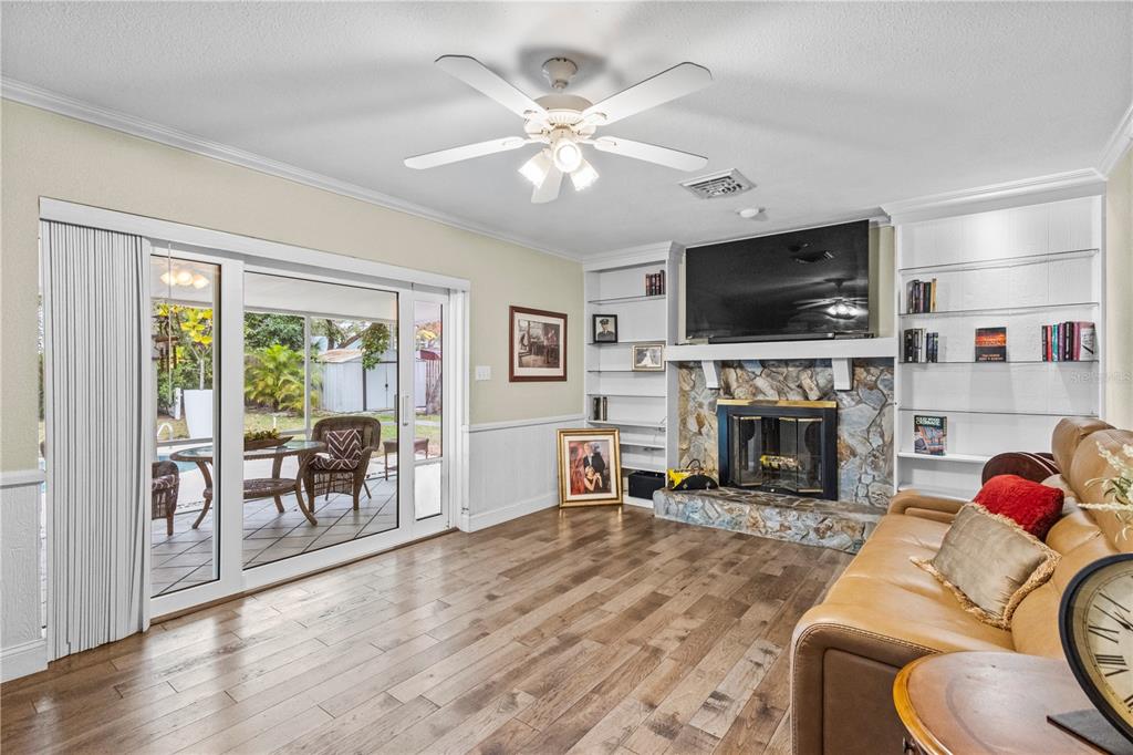 1437 Glenview Road Palm Harbor, FL 34683 - Photo 44 of 69 a living room with furniture a fireplace and a flat screen tv