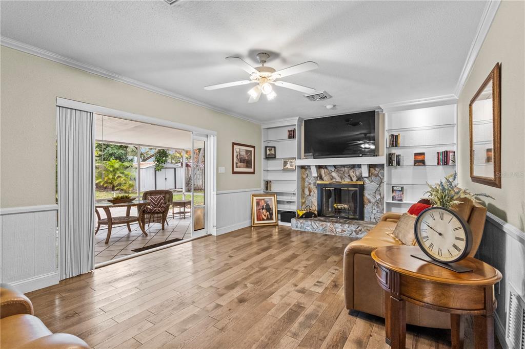 1437 Glenview Road Palm Harbor, FL 34683 - Photo 45 of 69 a living room with furniture a flat screen tv and a fireplace