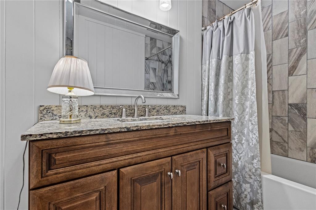 1437 Glenview Road Palm Harbor, FL 34683 - Photo 57 of 69 a bathroom with a granite countertop sink and a mirror