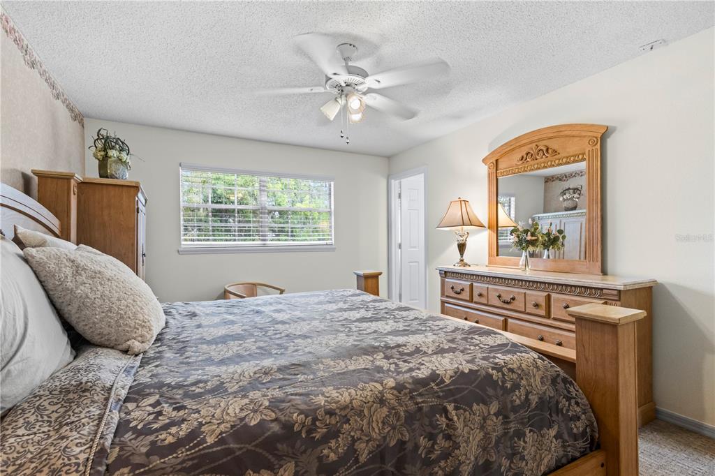 1437 Glenview Road Palm Harbor, FL 34683 - Photo 58 of 69 a bedroom with a large bed and a chandelier