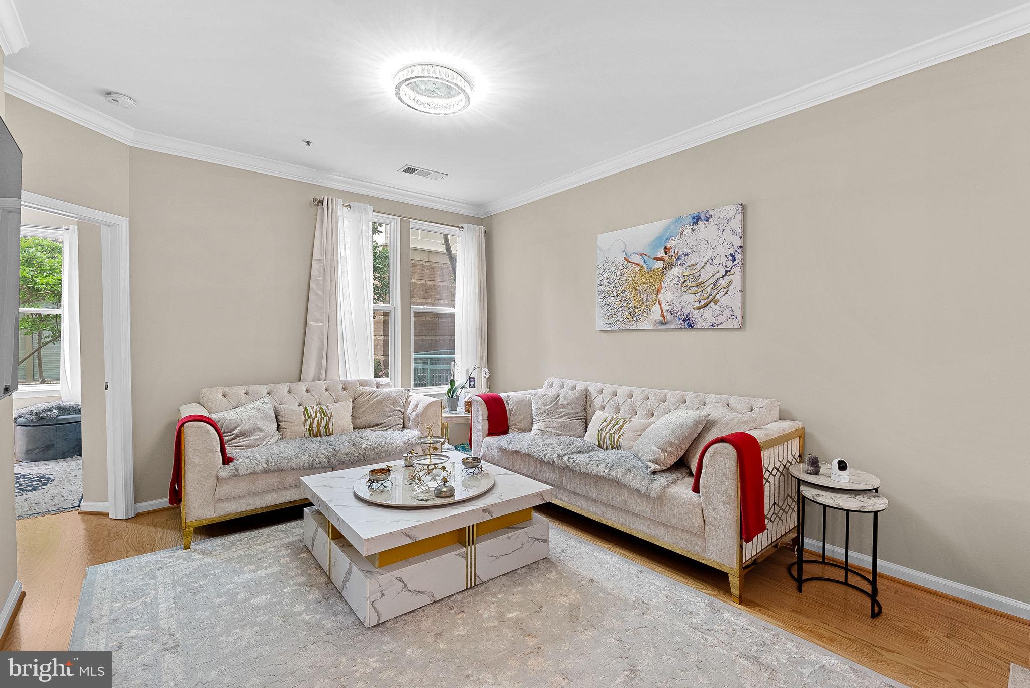12001 Market Street, Unit 106 Reston, VA 20190 - Photo 11 of 45 a living room with furniture and a large window