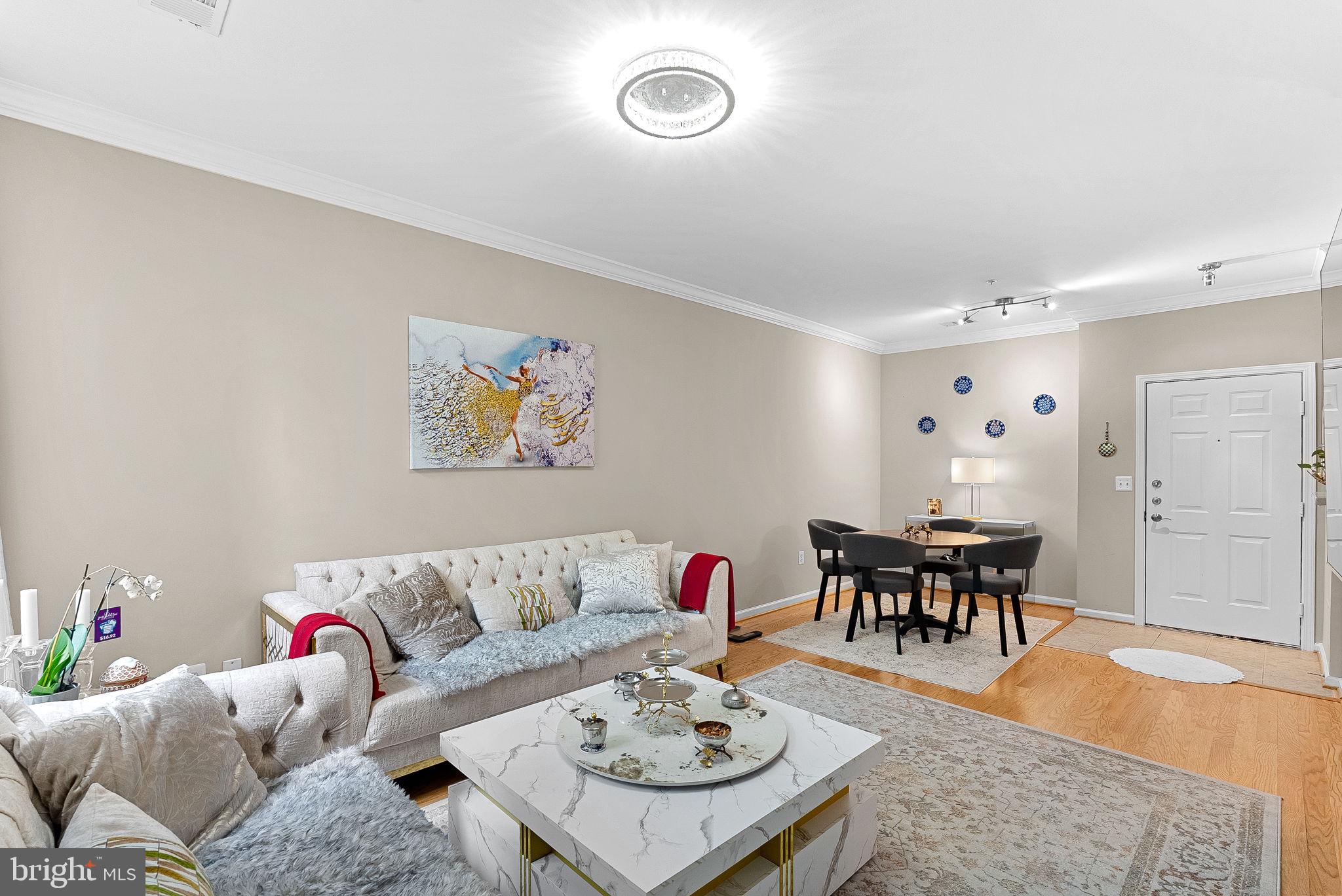 12001 Market Street, Unit 106 Reston, VA 20190 - Photo 13 of 45 a living room with furniture and wooden floor