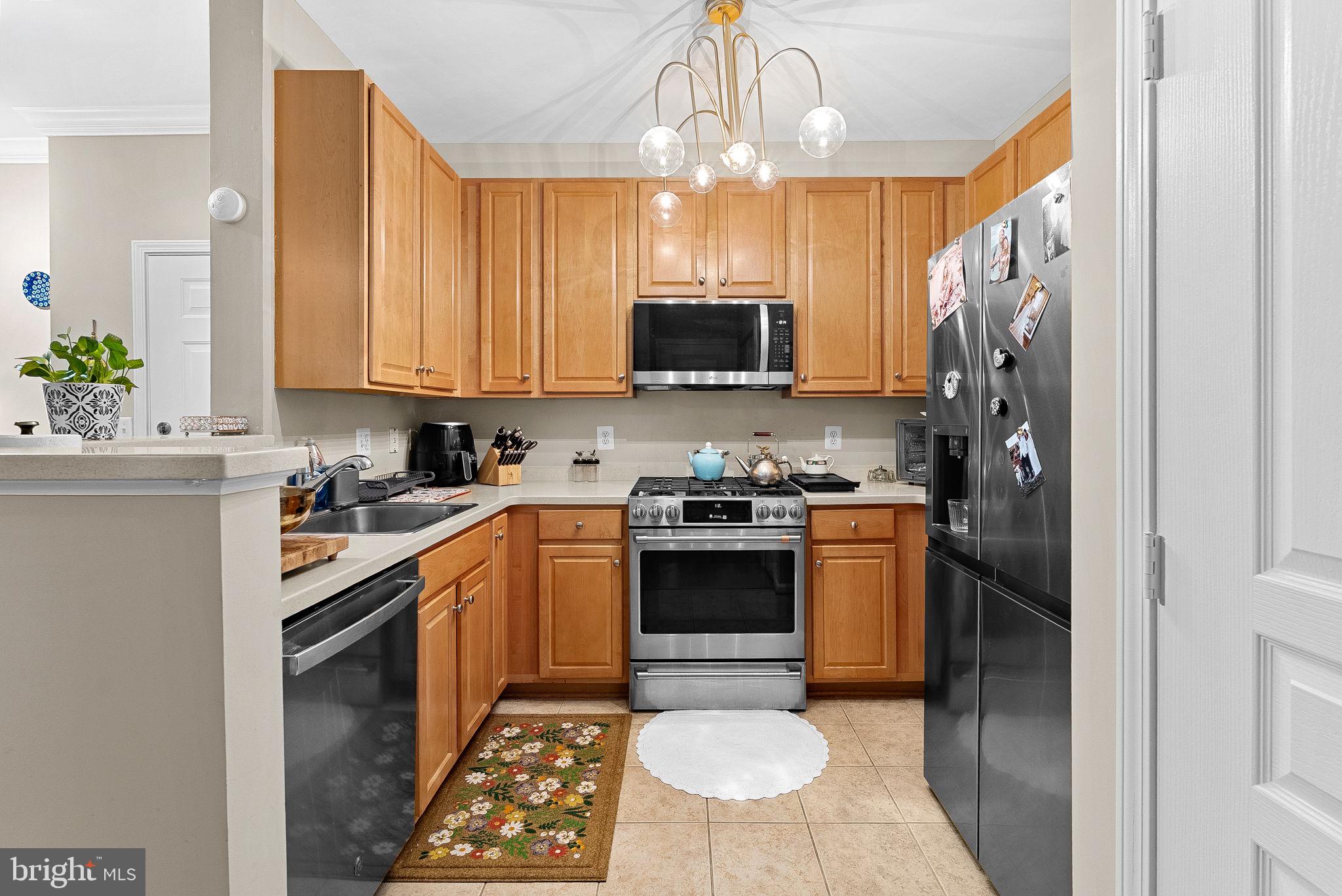 12001 Market Street, Unit 106 Reston, VA 20190 - Photo 14 of 45 a kitchen with stainless steel appliances a stove refrigerator sink and microwave